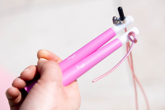 Pink Freyja fit skipping rope held by a hand against a light background