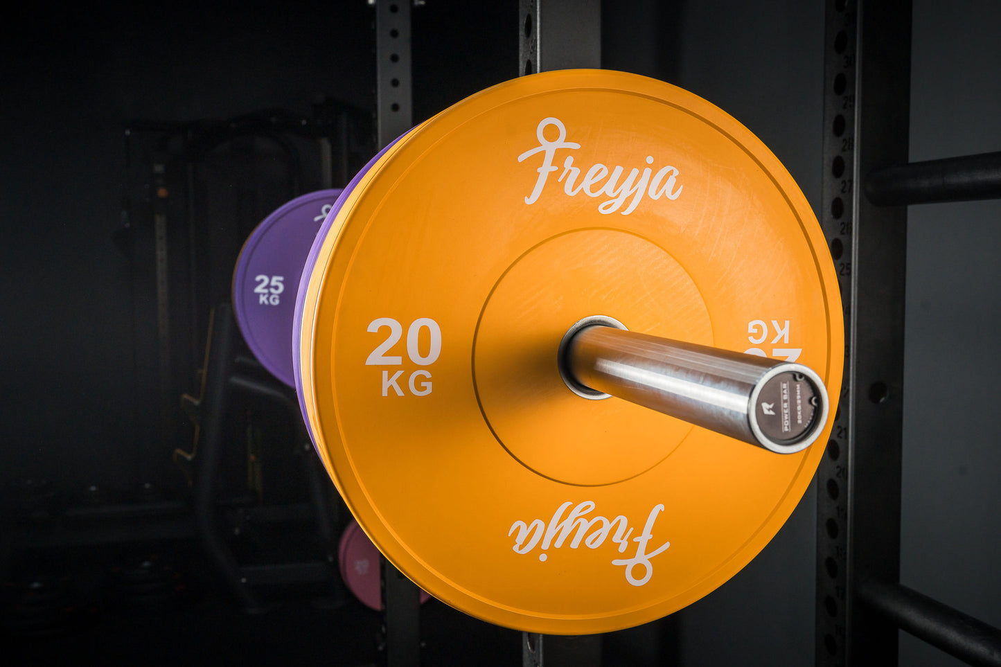 Orange Freyja Fit bumper plate on a barbell for gym and weightlifting