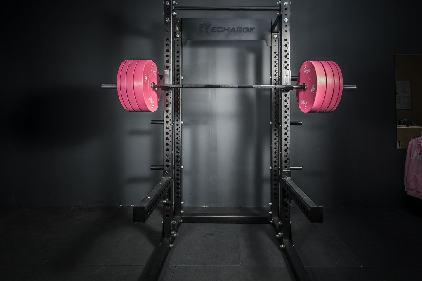 Black squat rack with pink Freyja Fit bumper plate sets