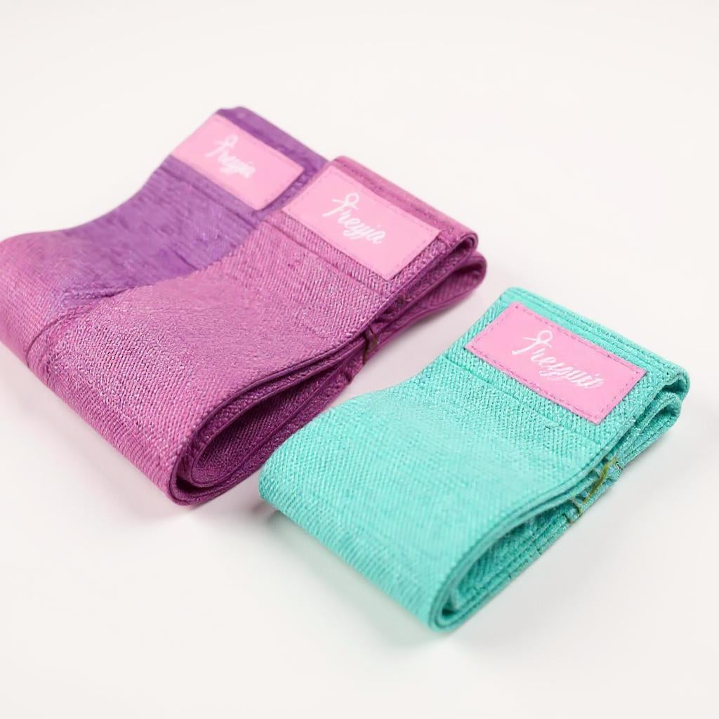 Pack of three Freyja Fit pastel glute bands in purple, pink, and aqua, displayed on a white background.