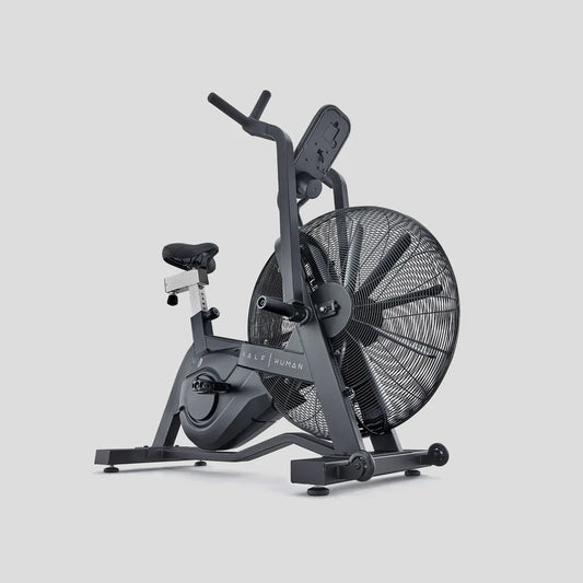 Black half human exercise air bike on a light grey background