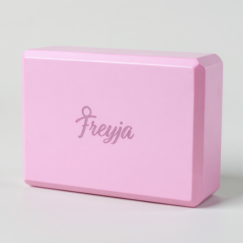Pink Freyja yoga block with 'Freyja' branding on a light grey background