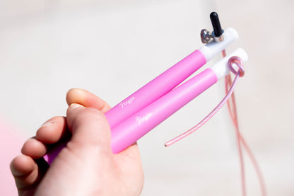 Pink Freyja fit skipping rope held by a hand against a light background