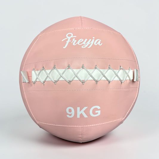 Pink exercise wall ball with 'Freyja' branding and '9KG' marking 