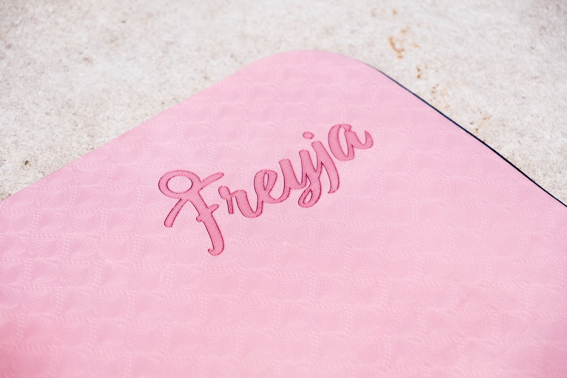 Close-up of pink Freyja Fit yoga mat with Freyja embroidery