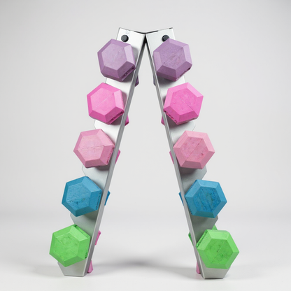 A set of pastel hex dumbbells in purple, pink, blue, and green on a silver rack against a white background.