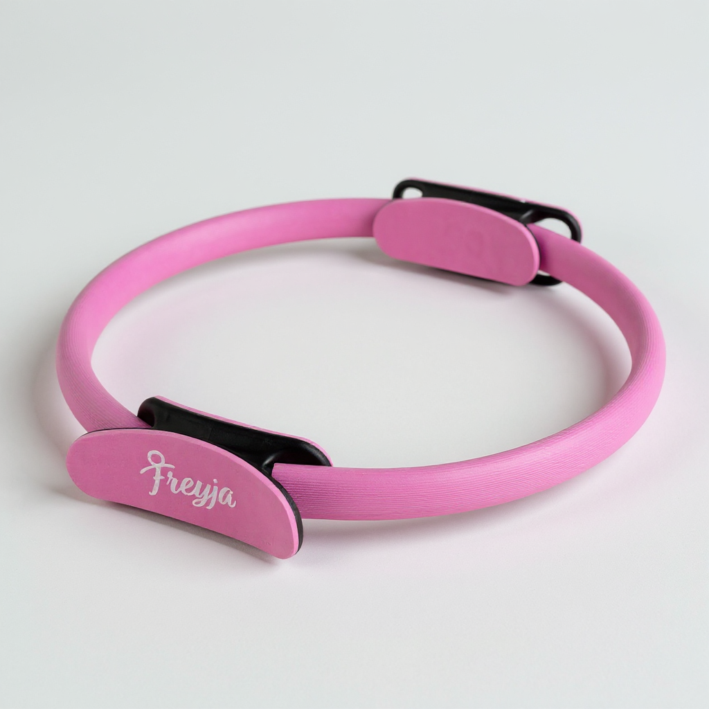 Pink freyja pilates ring with padded handles on a white background