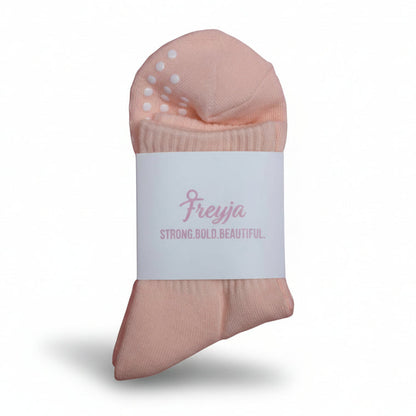 peach grip socks with Freyja branding on 