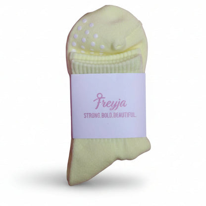 yellow grip socks with Freyja branding on 