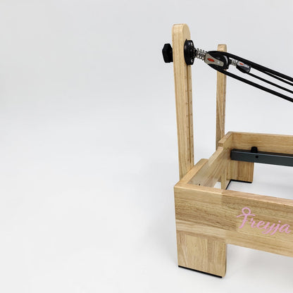 reformers pilates Wooden frame with black cables and 'Freyja' branding on a white background